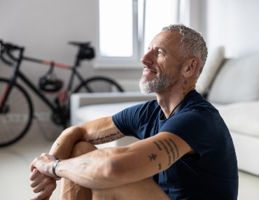 Athletic man in living room with bike in background, has great performance from IV Therapy